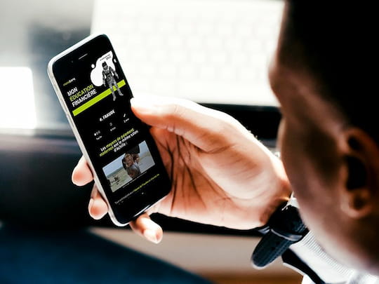 Homme regarde son téléphone sur l'application du programme d'éducation financière